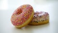 Close up of two delicious sweet tasty colorful donuts glazed and sprinkles isolated on white background Royalty Free Stock Photo