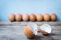 Close-up of two egg shell and fresh eggs on wooden background Royalty Free Stock Photo