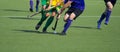 Close up of two field hockey players, challenging eachother for the control and posession of the ball during an intense, competiti Royalty Free Stock Photo