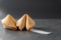 Close-up of two fortune cookies with a blank fortune coming out of it on a black slate background with copy space Royalty Free Stock Photo