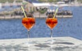 Close up of two glasses of chilled cocktail drinks with straws and ice cubes on a table near the beach. Royalty Free Stock Photo