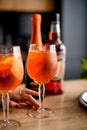 Close-up of two glasses of cold orange drink stand on the kitchen table.