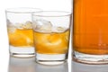 Close up on two glasses of whiskey on the rocks, with a whiskey bottle in white background Royalty Free Stock Photo