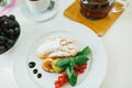 Close-up of two gold wedding rings on a croissant with powdered sugar on a plate with figs, red currants and mint leaves Royalty Free Stock Photo