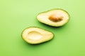 Close up of two halves of avocado and copy space on green background