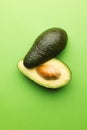 Close up of two halves of avocado and copy space on green background