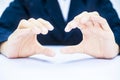 Close up of two hands of a business man wearing blue suit on white trying to save something imagery.