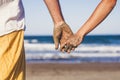 Close up of two hands holding between together at the beach with the hands dirty of sand - vacations outdoors in relationship Royalty Free Stock Photo