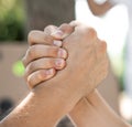 Two hands joined together as a greeting or as in armwrestling