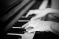 Close up of two hands playing piano, shallow focus. Black and white Royalty Free Stock Photo