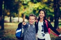 Close up two happy friends with backpacks looking and pointing with finger away Royalty Free Stock Photo