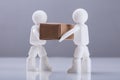 Close-up Two Human Figures Carrying Cardboard Box Royalty Free Stock Photo