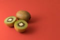 Close-up of two kiwis, one of them cut in half. Isolated on a red background Royalty Free Stock Photo