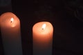 Close-up of two large white candles burning in the dark, selective focus Royalty Free Stock Photo