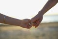 Close up of two Lovers Joining Hands. Detail Silhouette of Man and Woman holding hands over the Sunset Lake Background. Couple Tru Royalty Free Stock Photo