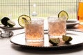 Close up of two margarita mocktails lit up from behind, garnished with lime slices. Royalty Free Stock Photo