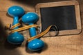 Old Blue Dumbbells with Tape Measure and Empty Blackboard Royalty Free Stock Photo