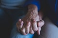 Close up of two old hands of couple of seniors together holding their hands each other at home - take care and in love lifestyle Royalty Free Stock Photo