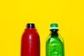 Close-up of two opened water bottles. Reusable steel thermo bottle of red color and disposable plastic bottle of green. Royalty Free Stock Photo