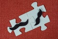 Close-up of two parts of puzzle. Symbolic men with a mustache. The concept of psychological compatibility, friendship.