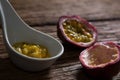 Two passion fruit and spoon with passion fruit pulp on wooden table Royalty Free Stock Photo