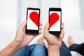 Two People With Mobile Phones Showing Halves Of Heart Shape Royalty Free Stock Photo