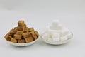 Close up two pile of brown sugar cubes on a white plate on white background Royalty Free Stock Photo