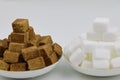 Close up two pile of brown sugar cubes on a white plate on white background Royalty Free Stock Photo