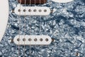 Close up of two single coil on white electric guitar, studio shoot. Black Pearl pickguard