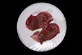 Beef heart slices in a white plate, on a black background Royalty Free Stock Photo