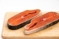 Close-up of two slices of raw red fish salmon on wooden board isolated on white background Royalty Free Stock Photo