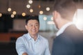 Close up of two smiling businessmen are handshaking after a successful deal in modern office Royalty Free Stock Photo