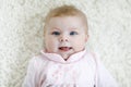 Close-up of a two or three months old baby girl with blue eyes. Newborn child, little adorable peaceful and attentive Royalty Free Stock Photo