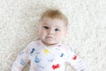 Close-up of a two or three months old baby girl with blue eyes. Newborn child, little adorable smiling and attentive