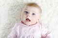 Close-up of a two or three months old baby girl with blue eyes. Newborn child, little adorable smiling and attentive Royalty Free Stock Photo