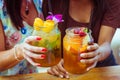 Close up of two women clink glasses with refreshing strawberry apple cocktail with lime and peach mint cold coctail Royalty Free Stock Photo