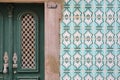 Close-up of a typical entrance door surrounded by patterned tiles azulejos inside the old town of Tavira, Algarve