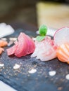 Close-up of a typical Japanese dish of sushimi with tuna salmon roll on a black background Royalty Free Stock Photo