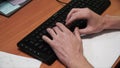 Close-up of typing male hands. Clip. Hands on keyboard. Close-up of male hand before touching button of black computer