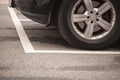 Close up of tyres car wheel from car parking inside white stipes at parking lot on asphalt Royalty Free Stock Photo