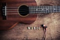 Close up of ukulele and earphone on old wood background