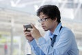 Close up of unemployed young Asian man looking mobile smart phone for find job. Unemployment concept. Royalty Free Stock Photo