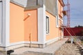 Close up on unfinished house paining walls and concrete path for foundation waterproofing.