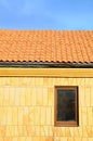 Close up unfinished roof. Roof house with tiled roof on blue sky. marble tile on the wall in a new window. Unfinished roof. Royalty Free Stock Photo