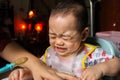 Close up of unhappy little seven months old son in see through plastic bib screaming and crying in chair for babies after mom made