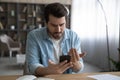 Close up unhappy man looking at phone screen, bad news