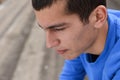 Close up of unhappy teenage student sitting outside on stadiu