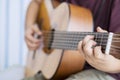 Unknown little boy is strumming acoustic guitar Royalty Free Stock Photo