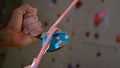 CLOSE UP: Unrecognizable belayer helps a climber descend after climbing a wall