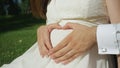 CLOSEUP Unrecognizable couple making heart shape with hands over pregnant belly Royalty Free Stock Photo
